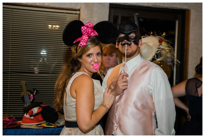 A bride and groom dress up for the photo booth